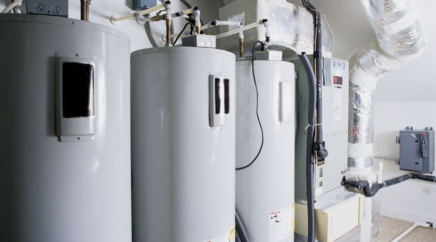 Water heaters in a residential setting, showcasing multiple units and plumbing connections, relevant to water heater repair and installation services.