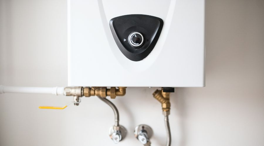 Tankless water heater installation with control panel and plumbing connections, relevant to plumbing maintenance and energy efficiency discussions.
